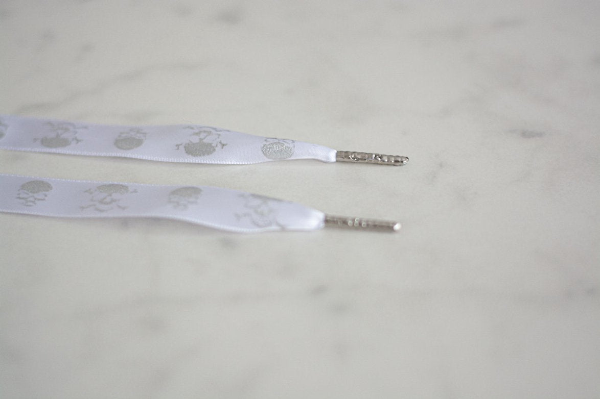 Schoenveters plat Skull - wit met zilveren doodskopjes